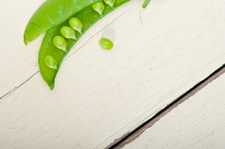 hearthy fresh green peas  over a rustic wood tableの写真素材