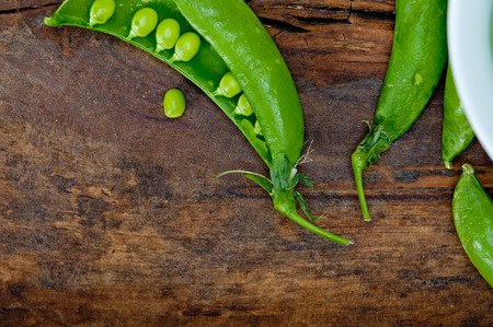 hearthy fresh green peas  over a rustic wood tableの写真素材