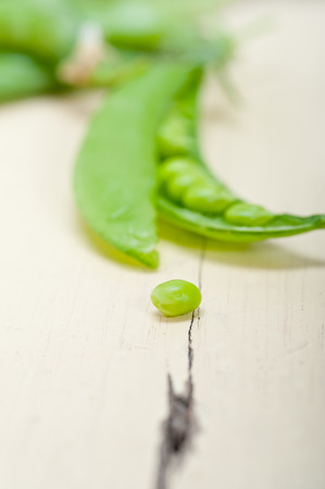 hearthy fresh green peas  over a rustic wood tableの写真素材