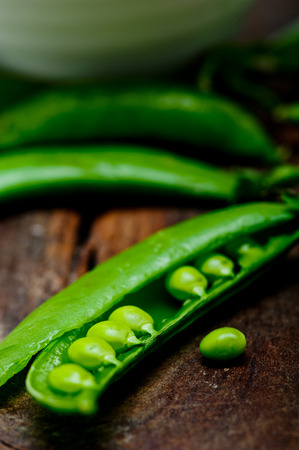 hearthy fresh green peas  over a rustic wood tableの写真素材