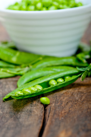 hearthy fresh green peas  over a rustic wood tableの写真素材