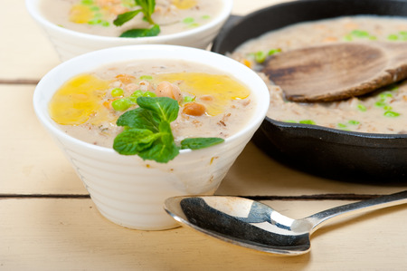 Hearty Middle Eastern Chickpea and Barley Soup with mint leaves on topの写真素材