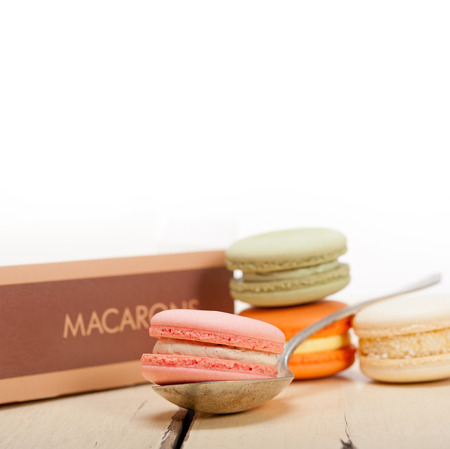colorful french macaroons over a white rustic wood tableの写真素材