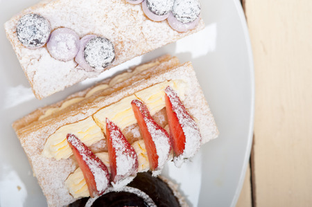 selection of fresh cream napoleon and chocolate mousse cake dessert plate
