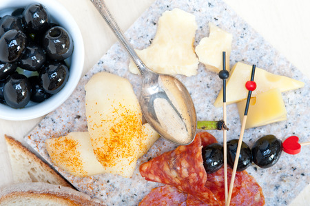 cold cut assortment cheese salami and fresh pears served on a granite stoneの写真素材