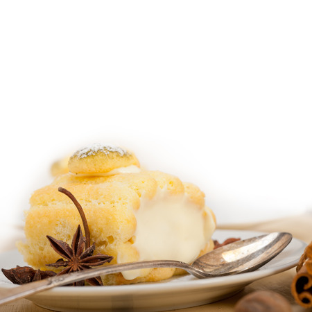 fresh homemade cream roll cake dessert and spices over white rustic wood table