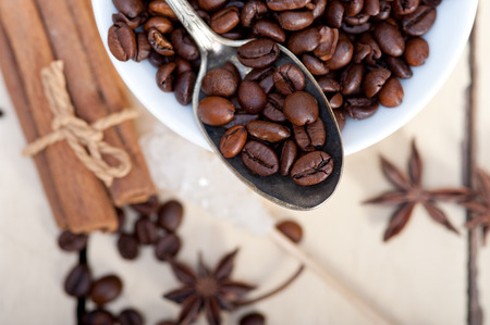 coffe sugar and spice on silver spoon over white wood rustic tableの写真素材