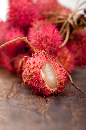 fresh tropical rambutan fruits over rustic wood tableの写真素材