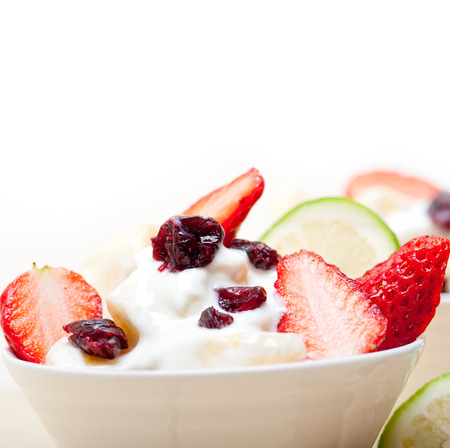 fruit and yogurt salad healthy breakfast over white wood tableの写真素材