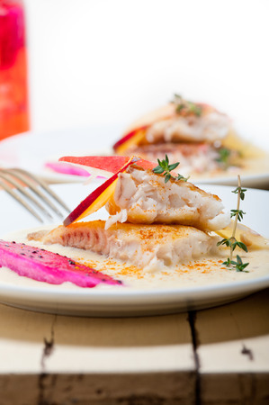 sea bream orata  fillet butter pan fried with fresh peach prune and dragonfruit slices thyme on topの写真素材