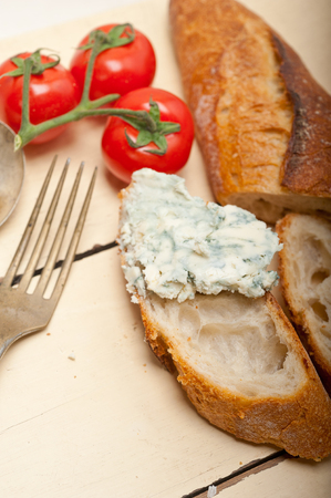 fresh blue cheese spread ove french baguette with cherry tomatoes on sideの写真素材