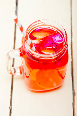 fresh fruit punch refreshing summer drink over white rustic wood tableの写真素材