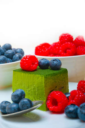 green tea matcha mousse cake with raspberries and blueberries on top