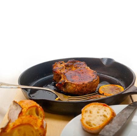 pork chop seared on iron skillet with lemon and spices seasoningの写真素材