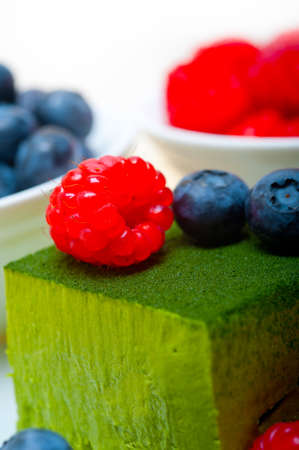 green tea matcha mousse cake with raspberries and blueberries on topの写真素材