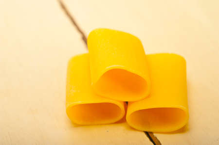 Italian pasta paccheri or schiaffoni macro closeup over white tableの写真素材