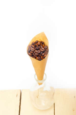 espresso coffee beans on a paper cone cornucopia over white backgroundの写真素材