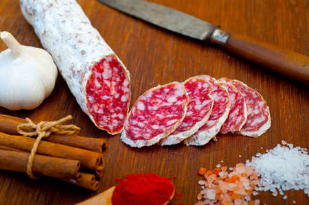 traditional Italian salame cured sausage sliced on a wood board