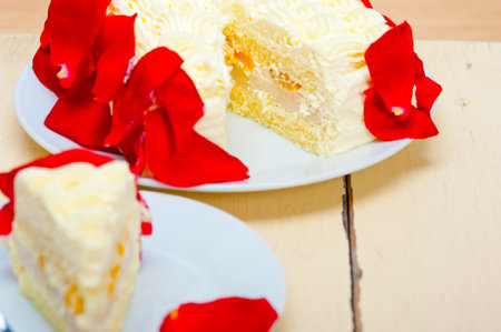whipped cream mango cake with red rose petalsの写真素材