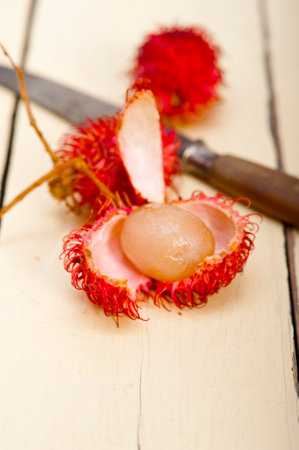 fresh tropical rambutan fruits over rustic wood tableの写真素材