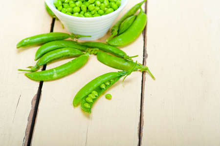 hearthy fresh green peas over a rustic wood table