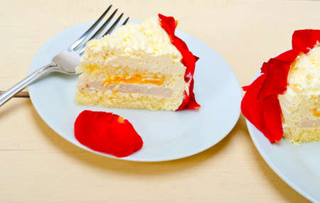 whipped cream mango cake with red rose petalsの写真素材