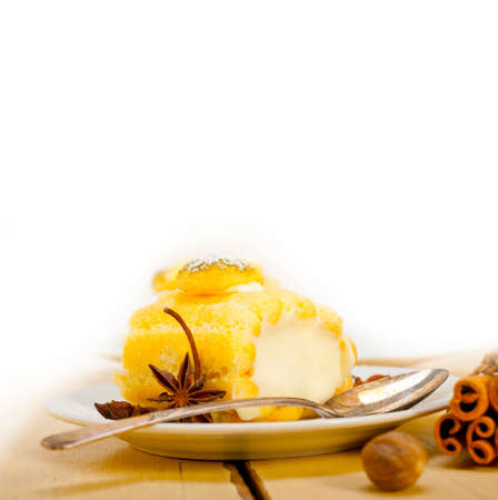 fresh homemade cream roll cake dessert and spices over white rustic wood tableの写真素材