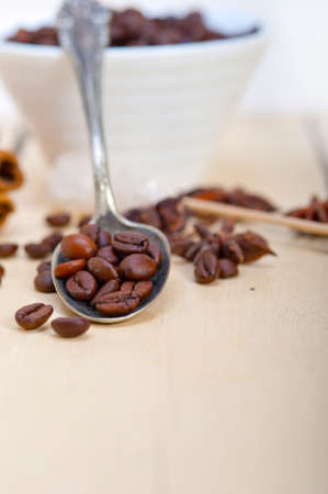 coffe sugar and spice on silver spoon over white wood rustic tableの写真素材