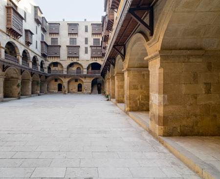 Facade of caravansary (Wikala) of Bazaraa, with vaulted arcades and windows covered by interleaved wooden grids (mashrabiyya), suited in Tombakshia street, Al Gamalia district, Medieval Cairo, Egyptのeditorial素材
