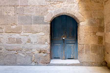 Blue wooden stained aged vaulted ornate door and stone wall, Medieval Cairo, Egyptの写真素材