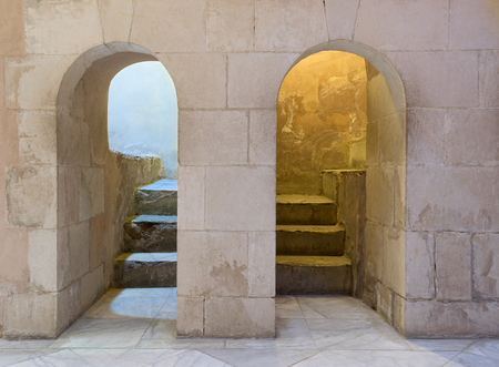 Two adjacent aged narrow dark vaulted passages and stone bricks wall, Medieval Cairo, Egyptのeditorial素材