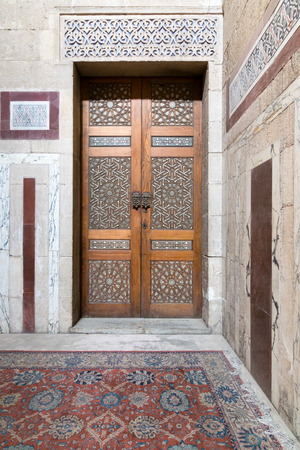 Ancient decorated door (arabesque) and decorated colored marble wall, Old Cairo, Egyptの写真素材