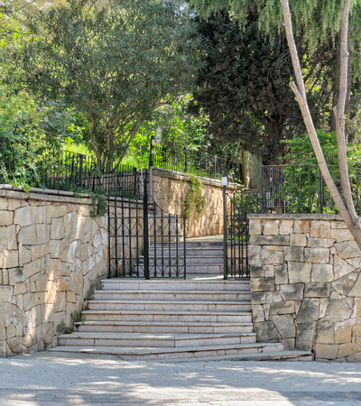 Ascending marble stairs leading to a public park, Stone wall, and fence iron door, Buyukada Island, Istanbul, Turkeyの写真素材
