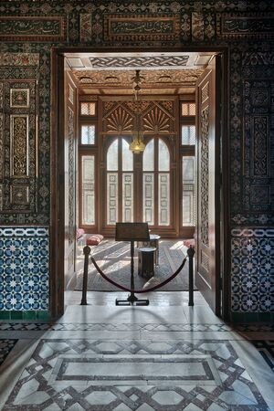 Cairo, Egypt - December 2 2017: Manial Palace of Prince Mohammed Ali. Entrance of a small room at reception hall with ornate wooden wall and ceiling, decorated wooden windows, lantern and ornate marble floorのeditorial素材
