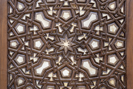 Closeup of arabesque ornaments of an old aged decorated wooden doorの写真素材
