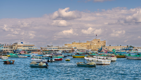 Alexandria, Egypt - December 3 2015: Old east harbor of Alexandria city at the Mediterranean Sea with fishing boats in the foreground and the Citadel of Qaitbay in the background in cloudy winter dayのeditorial素材