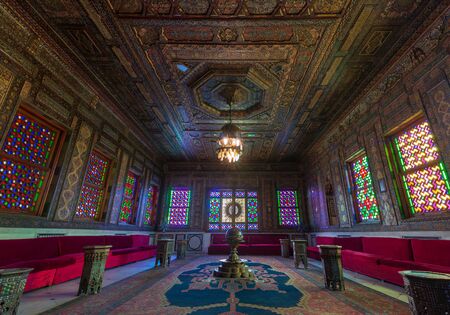 Manial Palace of Prince Mohammed Ali - Open for public. Syrian Hall with ornate wooden wall and ceiling, windows with colored stained glass and Ottoman Empire logo, Cairo, Egyptのeditorial素材