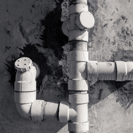 Plastic drainage pipes on white gauge stone wall