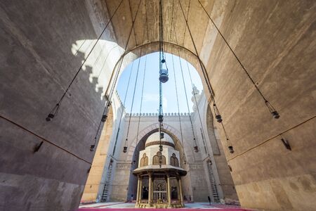 Cairo, Egypt - December 16, 2017: Courtyard of the Mosque of Sultan Hasan with Ablution fountain and huge arch, and few tourists visiting the place at the early morningのeditorial素材