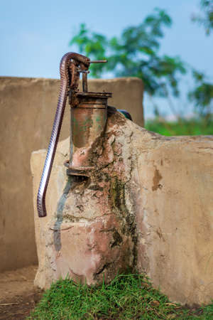 Local rusted traditional old hand operated water pump in a storage basin at an Egyptian rural villageの写真素材