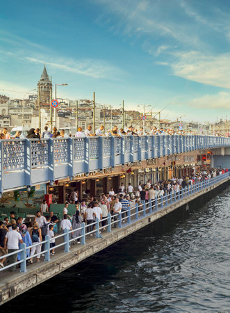 Istanbul, Turkey - August 30, 2022: Galata Bridge with traditional fish restaurants in the passage under the bridge, and crowds of People during Victory Day holiday with Galata Tower in the far endのeditorial素材