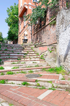 Walkway with red bricks stairs leading to old traditional building and trees, in sunny day, Balat district, Istanbul, Turkeyの写真素材