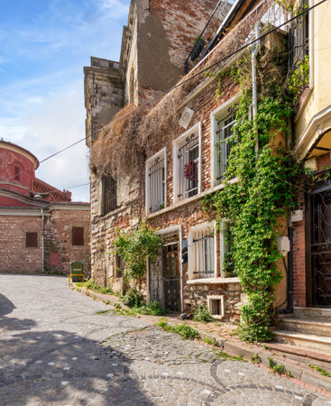 Cobblestone alley with beautiful old traditional red bricks houses in old Balat district, on a summer day, Istanbul, Turkeyの写真素材