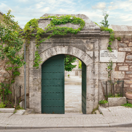 Arched entrance with green metal door in brick stone wall leading to 17th century Cinili Mosque in Uskudar, Istanbul, Turkeyの写真素材