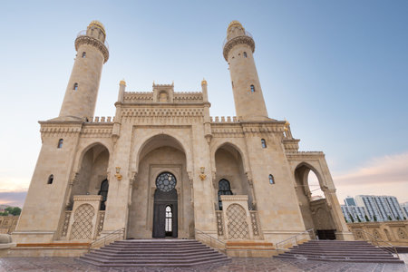 The majestic Taza Pir Mosque in Baku, Azerbaijan showcases intricate architecture with twin minarets against a peaceful early evening skyの写真素材