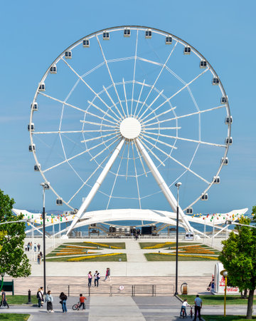 Baku, Azerbaijan - May 4, 2024: A view of the Baku Eye Ferris Wheel, located beside Deniz Mall. The wheel is in the background with people walking in the foreground.のeditorial素材