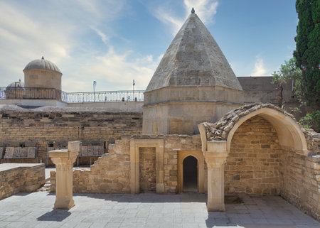 The historical Mausoleum of Seyid Yahya Bakuvi stands in the Old City, Icherisheher, in Baku, Azerbaijan. It features a distinctive conical roof and ancient stone architectureの写真素材