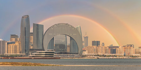 View of the Crescent Development Project in Baku, Azerbaijan, highlighting its unique architecture with a striking rainbow in the background during a clear dayの写真素材