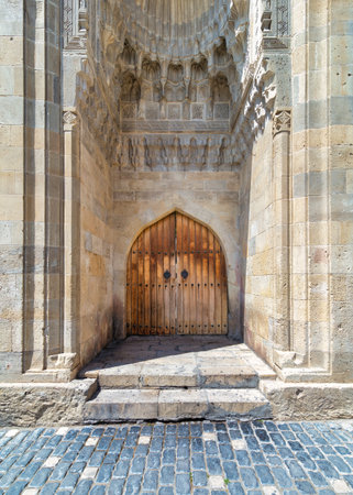 Exquisite wooden arched door, intricately carved with historical motifs. Suited at the Old City, or Icherisheher, Baku, Azerbaijan, leading to the Palace of the Shirvanshahsの写真素材