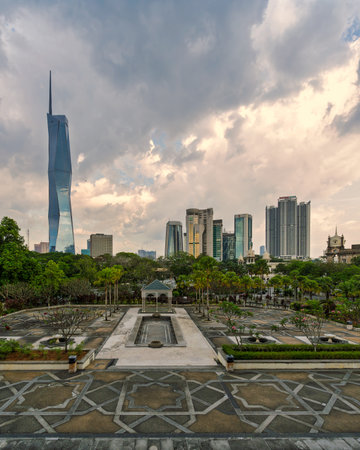 Kuala Lumpur, Malaysia - March 1, 2025: Merdeka 118 skyscraper and skyline. View from the national Mosque park with patterned paving and lush greenery under a cloudy skyの写真素材